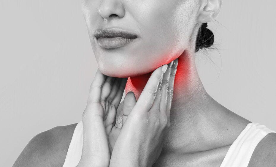 woman touching her throat because of loss of voice